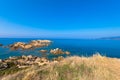 Turquoise Mediterranean sea with cumulus clouds at the Plage de l`Alga on the rocky coast of La Revellata near Calvi.